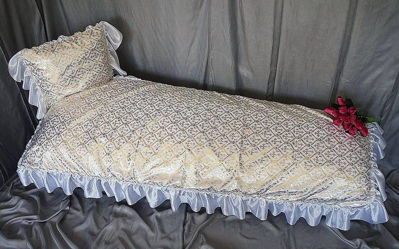 На фото - Стеганный комплект в гроб (покрывало и подушка) от ритуальной службы ГорСпецРитуал в Орле